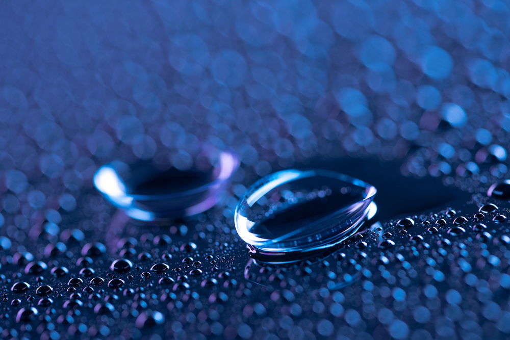 selective focus of contact lenses and water drops on blue background lentillas